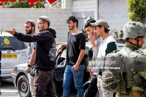 Jewish settlers protest against the Palestinians while the Israeli army forces guard in the town of Hawara, south of the city of Nablus, in the...