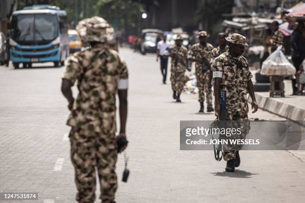 Soldiers from the Nigerian Armed Forces patrol and secure the streets in Lagos Island, Lagos, on February 27 after hoodlums had harassed market...