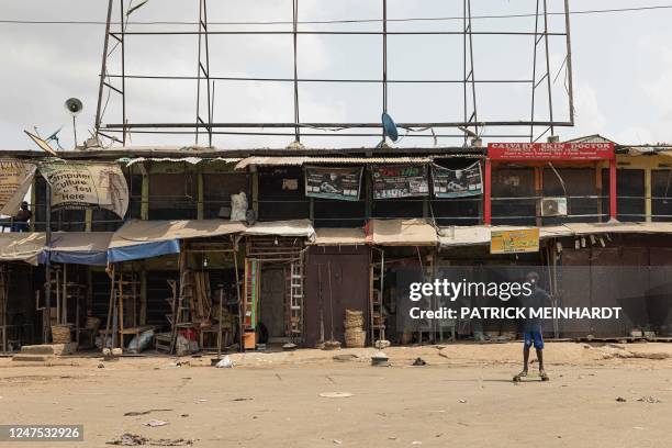Boy skateboards past closed shops during a 'sit-at-home' at a Market in Onitsha, on February 27 following the Nigeria presidential and general...