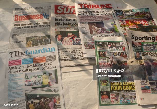 Nigerians in Lagos follow the developments regarding the general election results from the newspapers, on February 27, 2023. The unofficial results...