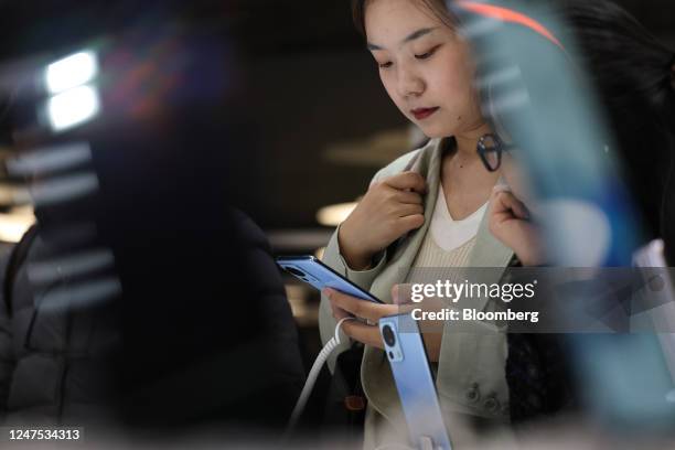 An attendee inspects a Xiaomi 13 smartphone device at the Xiaomi Corp. Stand on the opening day of the Mobile World Congress at the Fira de Barcelona...
