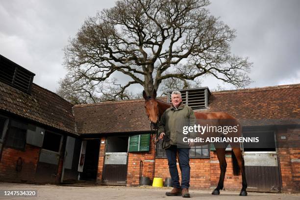 Racehorse trainer Paul Nicholls poses for a photograph alongside Bravemansgame during a press day at his Manor Farm stables in Ditcheat near Shepton...