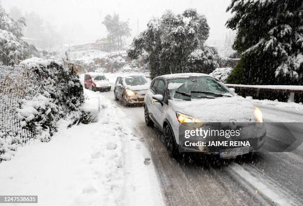 Cars travel on a snow-covered road close to the mountain village of Valldemossa on the Spanish Balearic island of Mallorca, on February 27, 2023. -...