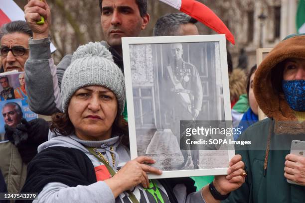 Protester holds a picture of Reza Shah, grandfather of Reza Pahlavi, during the demonstration. Protesters staged a rally in Parliament Square against...