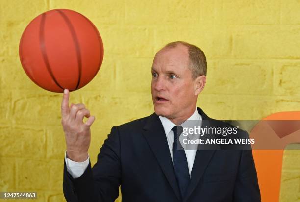 Actor Woody Harrelson spins a basketball on his fingertip as he arrives for the New York premiere of "Champions" at AMC Lincoln Square in New York...