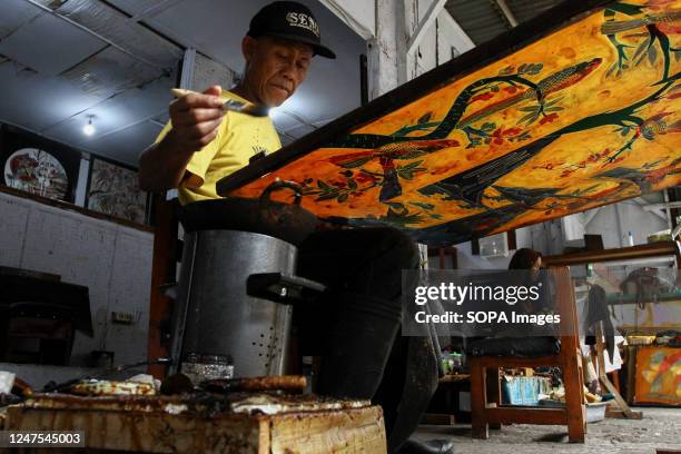 Craftsman works on a hand-drawn batik for a wall decoration at the Batik Seno Gallery, Yogyakarta. Decorative batiks sell for anything between...