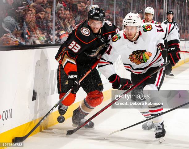 Jakob Silfverberg of the Anaheim Ducks and Taylor Raddysh of the Chicago Blackhawks battle for the puck during the first period at Honda Center on...