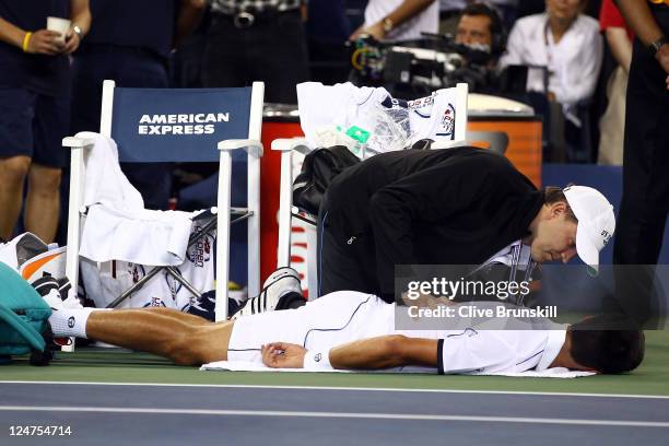 Novak Djokovic of Serbia has his back treated by ATP Trainer Clay Sniteman after the third set against Rafael Nadal of Spain during the Men's Final...