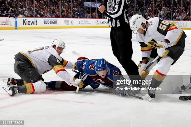 Ben Meyers of the Colorado Avalanche vies for possession against Brett Howden and Keegan Kolesar of the Vegas Golden Knights at Ball Arena on...