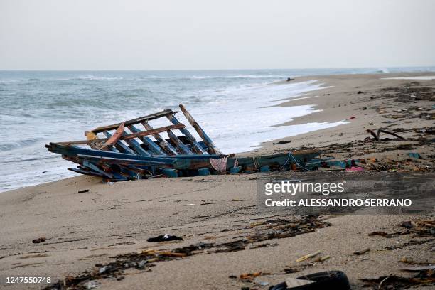 Photograph taken on February 28, 2023 shows parts of a migrants boat, washed on the beach, two day after it sank off Italy's southern Calabria...