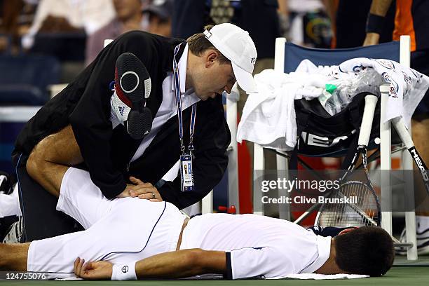 Novak Djokovic of Serbia receives treatment on his back from ATP Trainer Clay Sniteman against Rafael Nadal of Spain during the Men's Final on Day...