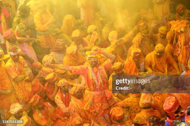 In this photograph taken on February 27 devotees smear with colours as they celebrate Hindu spring festival of Holi at Shreeji temple in Barsana,...