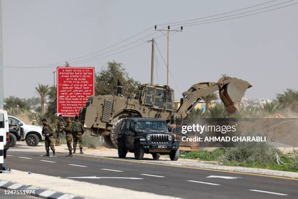 An Israeli military bulldozer moves to block a back-road on a highway where the army set up a checkpoint at the entrance of Jericho city in the...