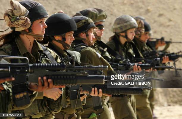 Female Israeli combat soldiers of the Caracal light infantry Battalion hold up their M-16 rifles at a shooting range in Ein Yahav, southern Israel,...