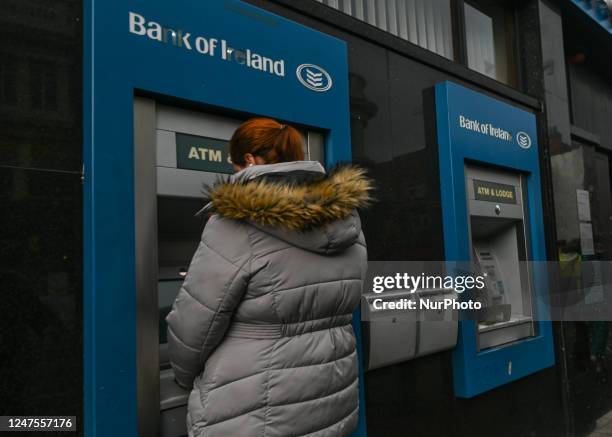 Woman uses Bank of Ireland's ATM in Dublin city center, in Dublin, Ireland, on February 17, 2023.