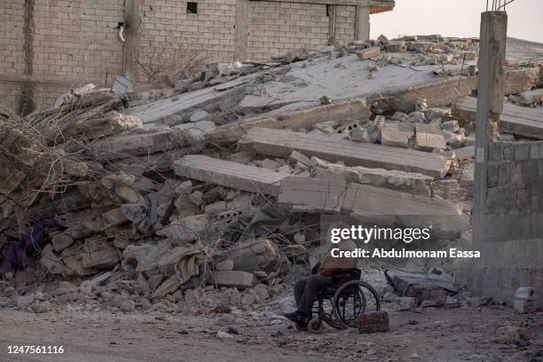 Man in a wheelchair sits amidst the rubble in the city of Jindires on February 28, 2023 near Aleppo, Syria. A 7.8-magnitude earthquake hit near...