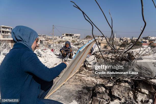 Jasmine, 23 years old, paints amidst the rubble in the city of Jindires on February 28, 2023 near Aleppo, Syria. Jasmine lives in Afrin, a city near...