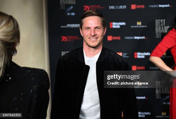 February 2023, Bavaria, Munich: Sebastian Steudtner, Big Wave world record holder, stands on the white carpet before the gala for the Best Brands...