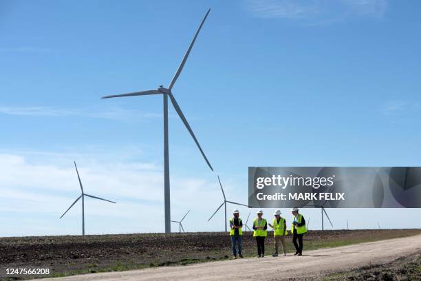 Engie employees walk down a road for a closer look at wind turbines during a tour for the dedication of the Limestone Wind Project in Dawson, Texas,...