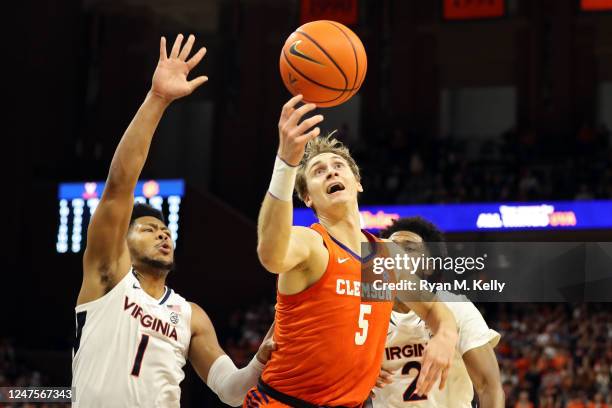 Hunter Tyson of the Clemson Tigers loses control of the ball between Jayden Gardner and Reece Beekman of the Virginia Cavaliers in the first half...