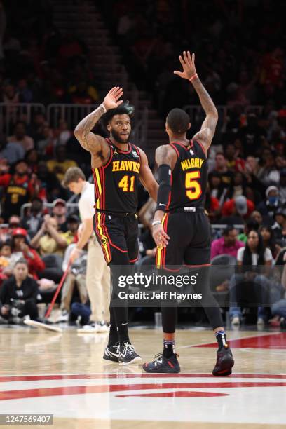 Saddiq Bey and Dejounte Murray of the Atlanta Hawks high five during the game against the Washington Wizards on February 28, 2023 at State Farm Arena...