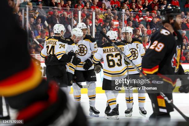 Brad Marchand of the Boston Bruins celebrates with teammates after a goal against the Calgary Flames at Scotiabank Saddledome on February 28, 2023 in...