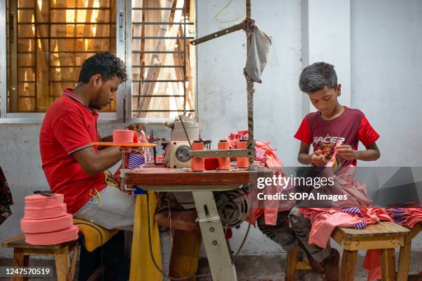 Kid working beside his colleague in a local ready-made garment . Child labour is restricted in ready-made garment sectors. However, there are still...
