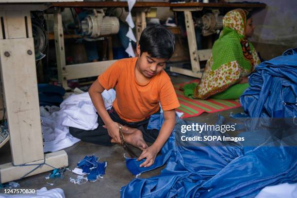 Kid working beside his elderly colleague in a local garment factory ready-made garment . Child labour is restricted in ready-made garment sectors....