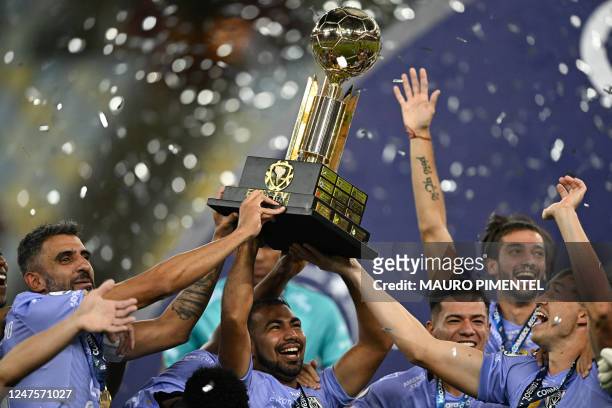 Independiente del Valle's midfielder Junior Sornoza lifts the trophy with teammates after winning the Conmebol Recopa Sudamericana by defeating...