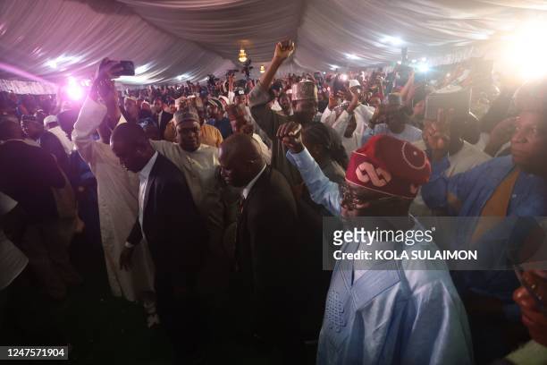 Ruling party candidate Bola Tinubu, acknowledges supporters in Abuja on March 1, 2023 during celebrations at his campaign headquarters. - Ruling...