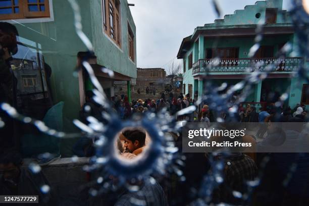 Young boy is seen through a bullet hole in the window of a house at Padgampora village in Awantipora of Pulwama district, south of Kashmir. Two...