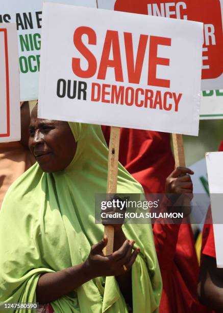 Woman displays a placard as a group of people protest the outcome of the 2023 presidential elections and the emergence of the candidate of All...