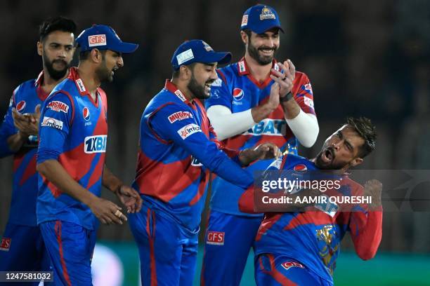 Karachi Kings' Mohammad Amir celebrates with teammates after taking the wicket of Peshawar Zalmi's Mohammad Haris during the Pakistan Super League...