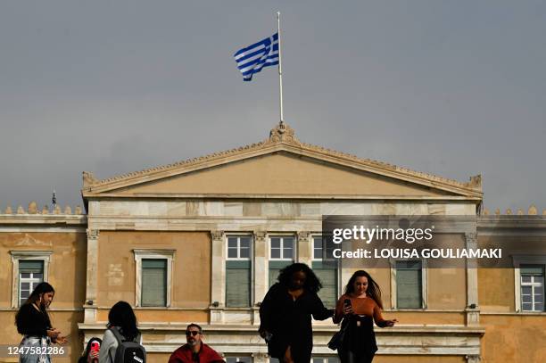 The Greek national flag flies at half mast above the Greek parliament in Athens on March 1, 2023 following the deadly train accident where at least...