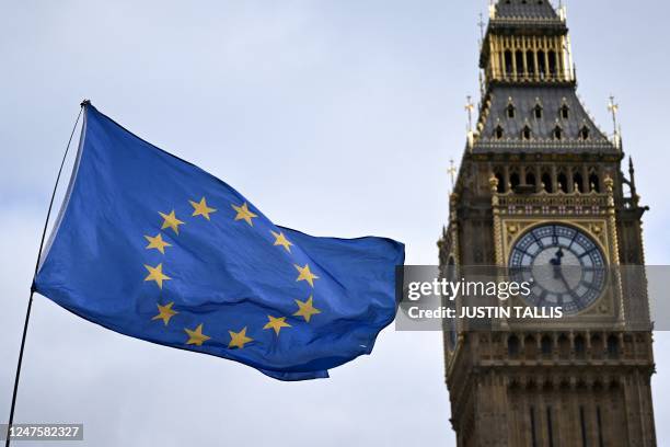 An EU flag, flown by anti-Conservative and anti-Brexit activists, flaps in wind, in front of the Elizabeth Tower, commonly known by the name of the...