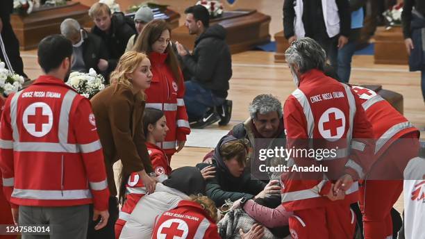 Relatives of people who died in a migrant shipwreck, mourn over the coffins at sports hall morgue in Crotone, Italy on March 01, 2023. The morgue...