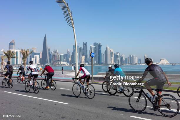 Cyclists ride along the corniche, in view of the commercial skyscrapers of the Qatar Financial Centre , in Doha, Qatar, on Tuesday, Feb. 14, 2023....