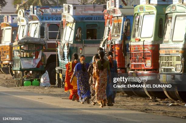 Indian sex workers walk past a row of parked trucks at a truck halt point along a national highway in Nelamangala, 21 January 2005. Transport Corp....