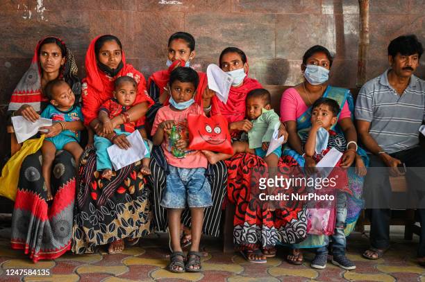Women wait in queue as they have come for a health check-up of their children, who are suffering from fever and respiratory problems, at a hospital...
