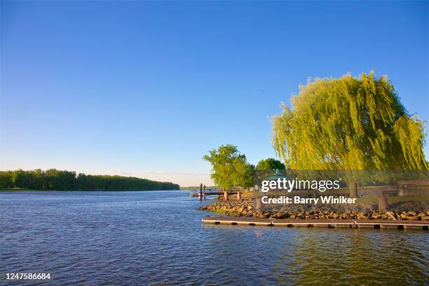 view of boat landing and trees in park on the hudson river, hudson, ny - new york spring spectacular stock-fotos und bilder