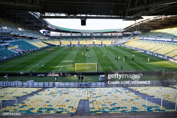 Tribunes are empty due to disciplinary measures as players warm up prior to the French Cup quarter-final football match between FC Nantes and RC Lens...