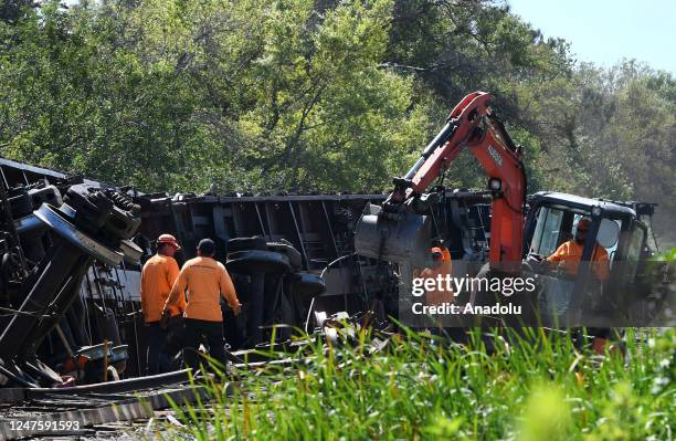 Workers clear the tracks after a Seminole Gulf Railway train derailed yesterday causing six train cars to overturn near Sarasota-Bradenton...