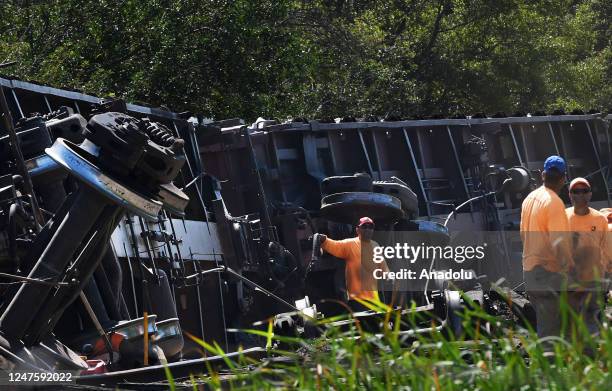 Workers clear the tracks after a Seminole Gulf Railway train derailed yesterday causing six train cars to overturn near Sarasota-Bradenton...