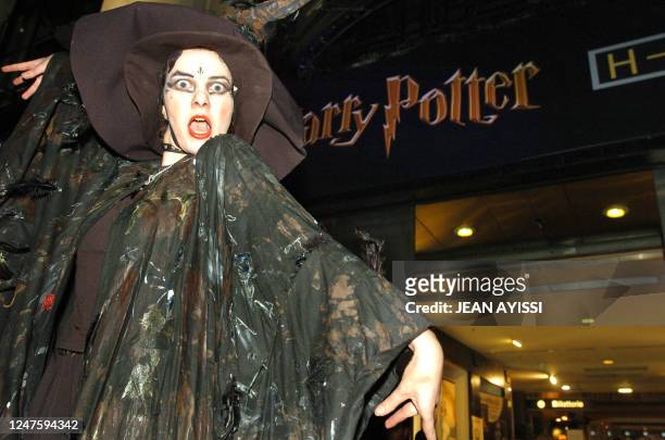 An actor dressed as a witch performs in front of Paris Champs Elysees bookstore 26 October 2007, before the start of sale of the French edition of...