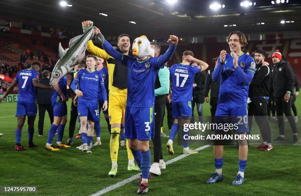 Grimsby's English defender Anthony Glennon wears a fish on his head whilst holding an inflatable fish as he celebrates with teammates after the...