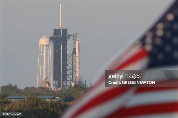 The SpaceX Falcon 9 rocket looms at dusk on the eve of its launch from the Kennedy Space Center in Florida on March 1, 2023. - The SpaceX Dragon...