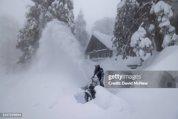 Robert Hallmark, who says that this is the worst snowstorm of his 31 years living here, clears snow at his home as residents throughout the San...