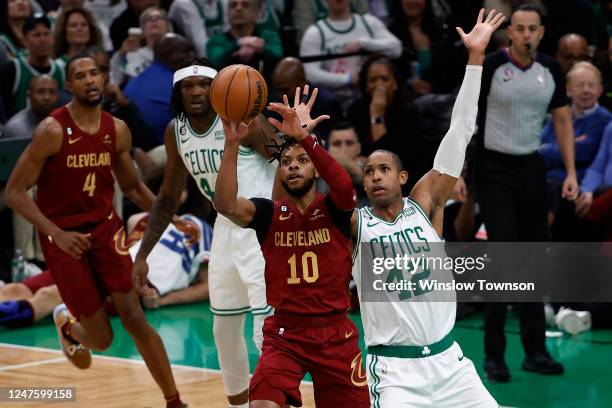 Darius Garland of the Cleveland Cavaliers passes the ball away from Al Horford of the Boston Celtics during the first quarter at TD Garden on March...