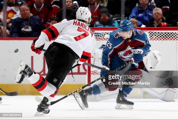 Logan O'Connor of the Colorado Avalanche deflects a shot by Dougie Hamilton of the New Jersey Devils at Ball Arena on March 1, 2023 in Denver,...