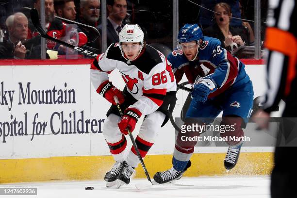Jack Hughes of the New Jersey Devils skates against Nathan MacKinnon of the Colorado Avalanche at Ball Arena on March 1, 2022 in Denver, Colorado.
